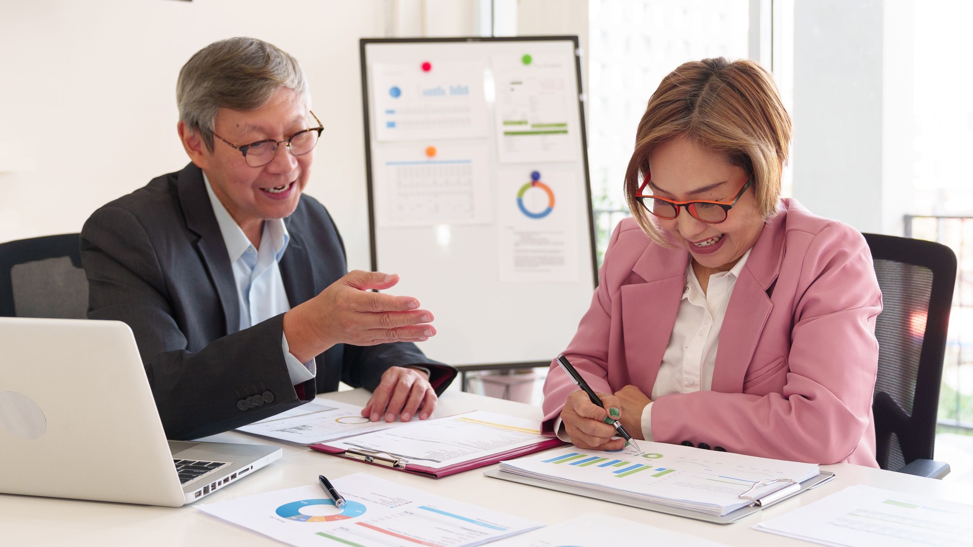Experienced executives analyzing financial data, reviewing company performance, and making strategic decisions for business growth.